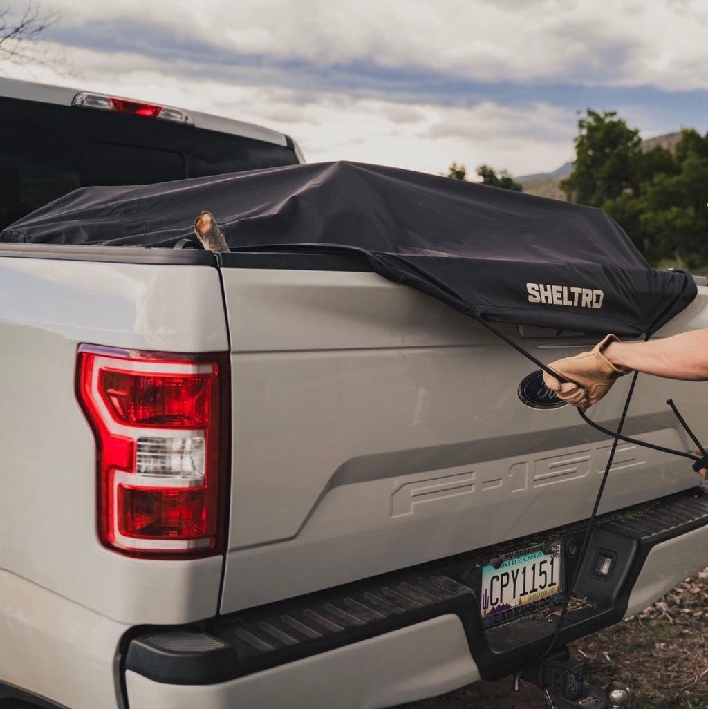 Sheltrd truck bed cover secured at the rear corner of a Ford F-150