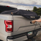 Sheltrd truck bed cover secured at the rear corner of a Ford F-150